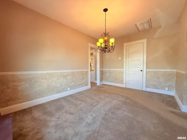 a view of an empty room with a chandelier