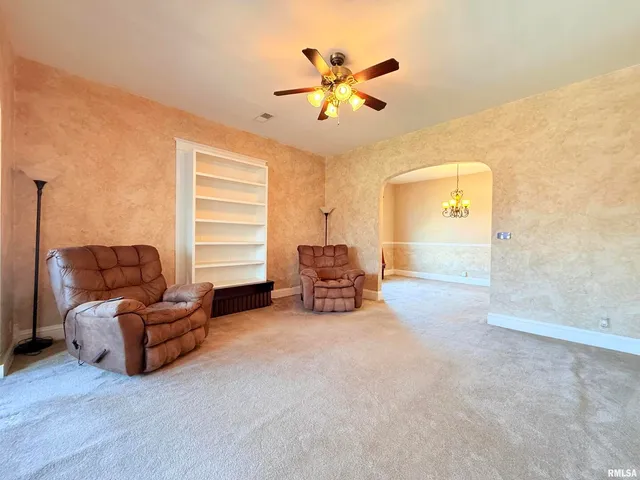 a living room with furniture and a ceiling fan