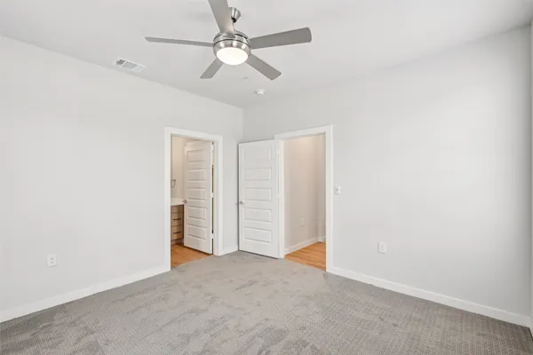 an empty room with a ceiling fan and a window