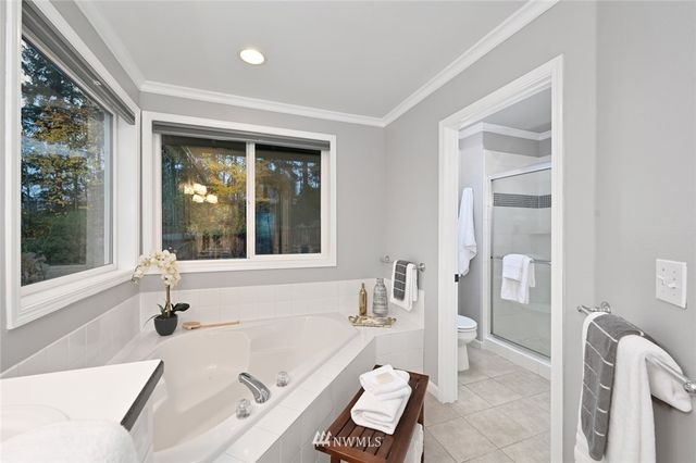 a bathroom with a tub a sink and a large window