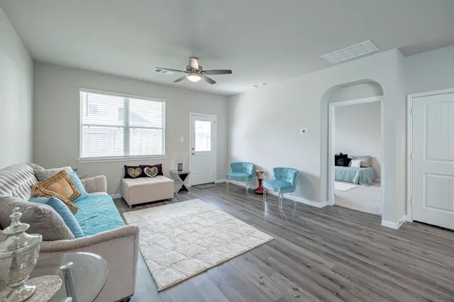 a spacious bedroom with a bed a couch and wooden floor
