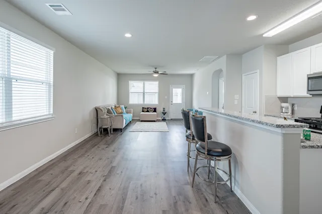 a living room with furniture and a wooden floor