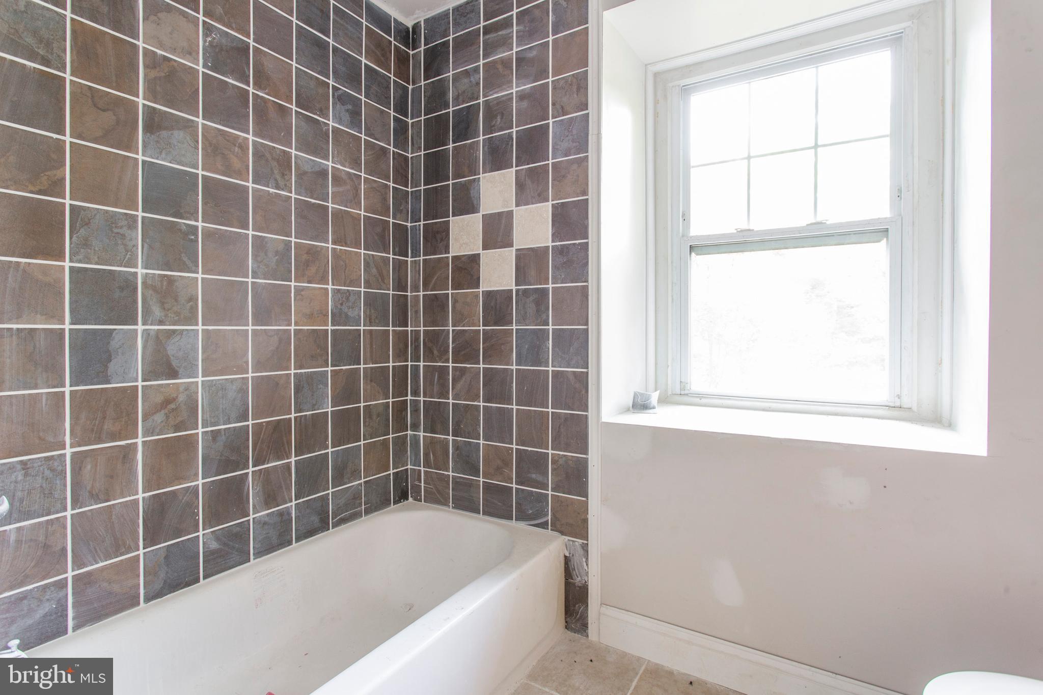 5200 Overbrook Avenue Philadelphia, PA 19131 - Photo 25 of 37 a bathroom with a bathtub and a window