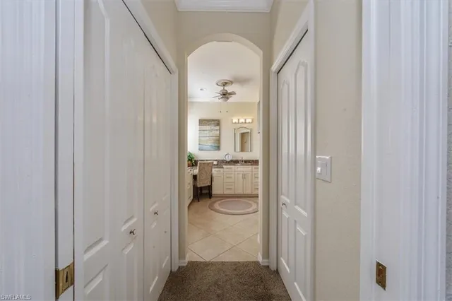 a view of a hallway with wooden floor and a bathroom