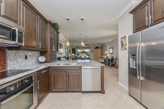 a kitchen with stainless steel appliances granite countertop a sink a stove and a refrigerator
