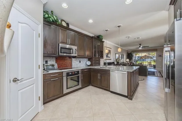 a kitchen with stainless steel appliances granite countertop a refrigerator oven a sink dishwasher and white cabinets with wooden floor