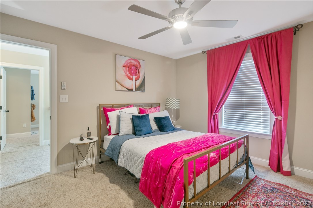 180 The Inner Circle Spring Lake, NC 28390 - Photo 43 of 50 a bedroom with a bed and a chandelier