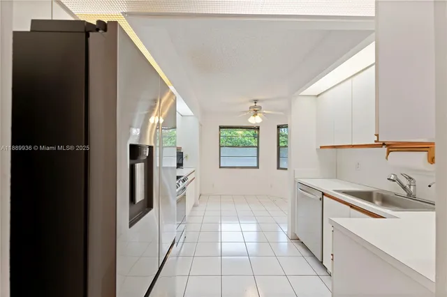 a kitchen with a sink a refrigerator and cabinets
