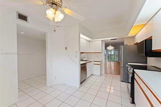 a kitchen with granite countertop a refrigerator and a stove top oven