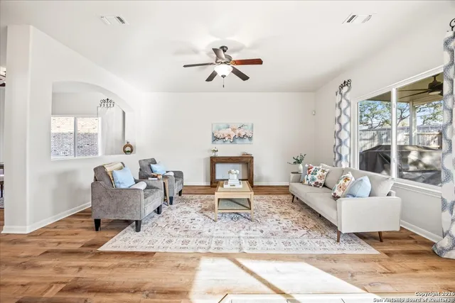 a living room with furniture floor to ceiling window and a rug