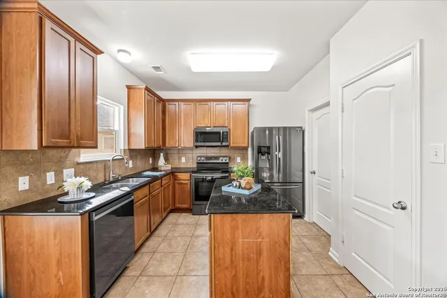 a kitchen with stainless steel appliances granite countertop a refrigerator and a stove top oven