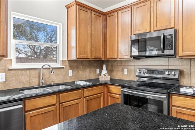 a kitchen with stainless steel appliances granite countertop a stove a sink and a microwave