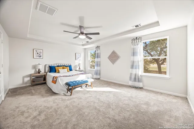 a spacious bedroom with a bed a window and couch