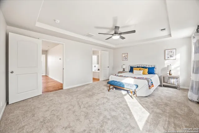 a spacious bedroom with a bed and ceiling fan