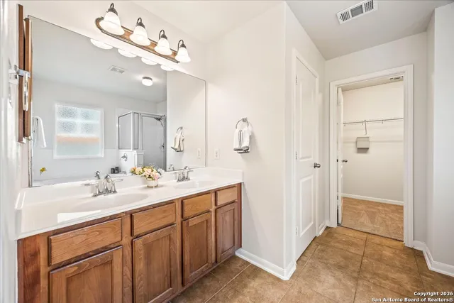 a spacious bathroom with a double vanity sink mirror and shower