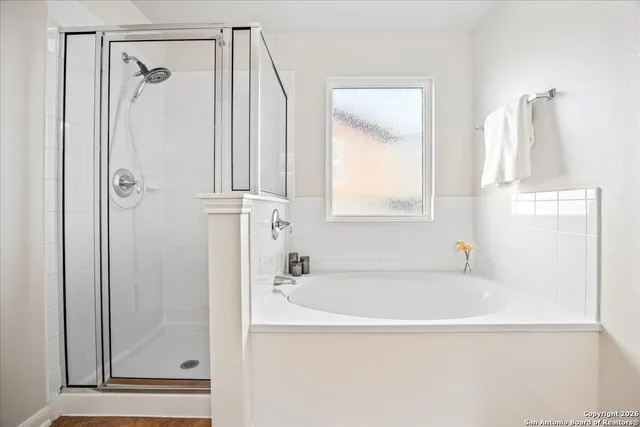 a white bath tub sitting next to a shower
