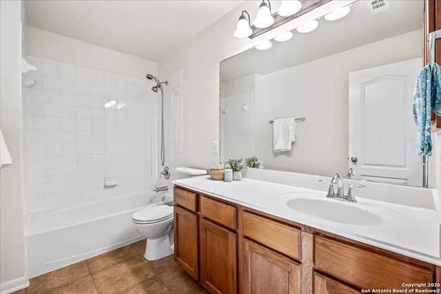 a bathroom with a double vanity sink toilet mirror and bathtub