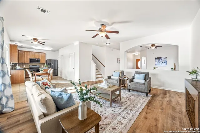 a living room with furniture kitchen view and a chandelier