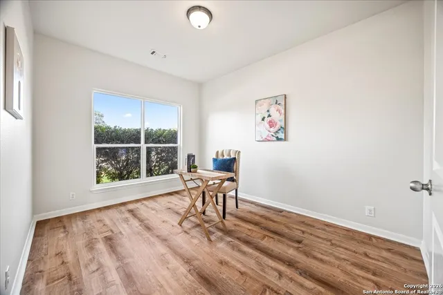 a view of a room with wooden floor and a window