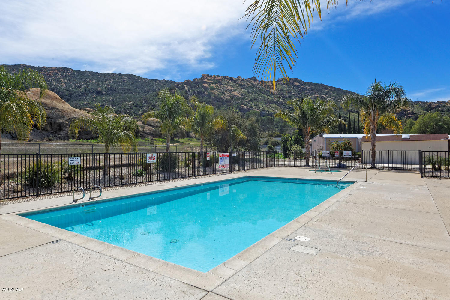 6480 Katherine Road, Unit 5 Simi Valley, CA 93063 - Photo 29 of 32 a view of a swimming pool with a table and chairs