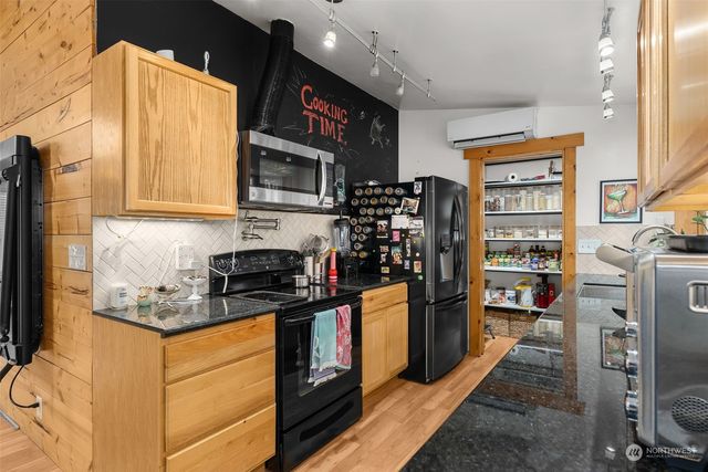 a kitchen with stainless steel appliances granite countertop a refrigerator and a stove top oven