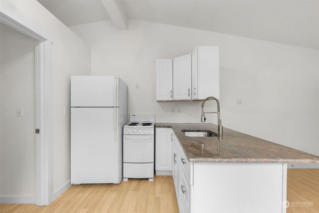a kitchen with a sink a refrigerator and a stove