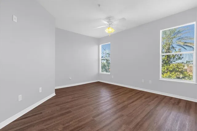 an empty room with wooden floor and window