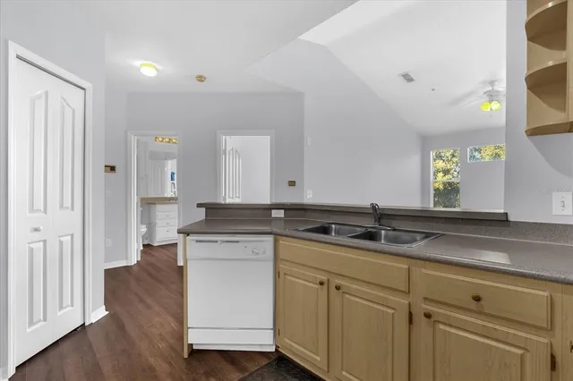 a view of cabinets a sink and a wooden floor in a room