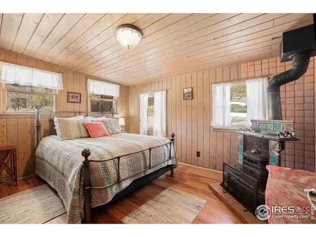 a spacious bedroom with a bed a couch and large window