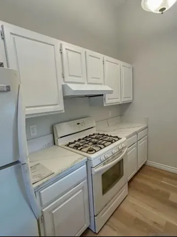 a white stove top oven sitting inside of a kitchen