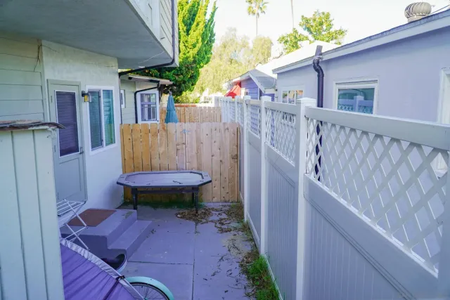 a view of a backyard with table and chairs and wooden fence