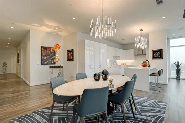 a view of a dining room with furniture a chandelier and wooden floor