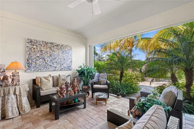 a view of a house with a palm tree and flower plants
