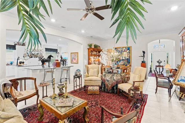 a living room with furniture kitchen view and a potted plant