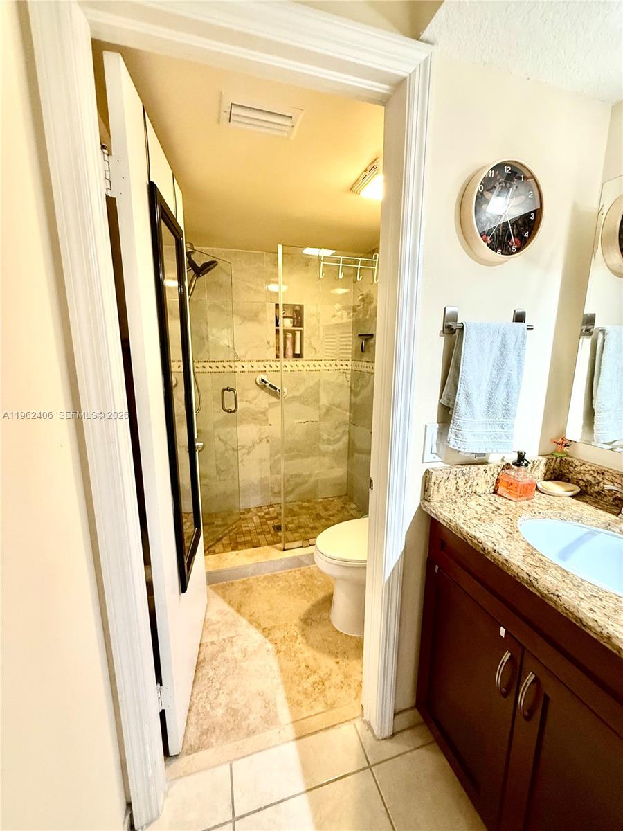 351 Club Circle, Unit 102 Boca Raton, FL 33487 - Photo 24 of 34 a bathroom with a sink a toilet a mirror and shower
