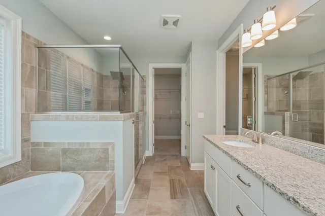 a bathroom with a granite countertop sink a mirror and a shower