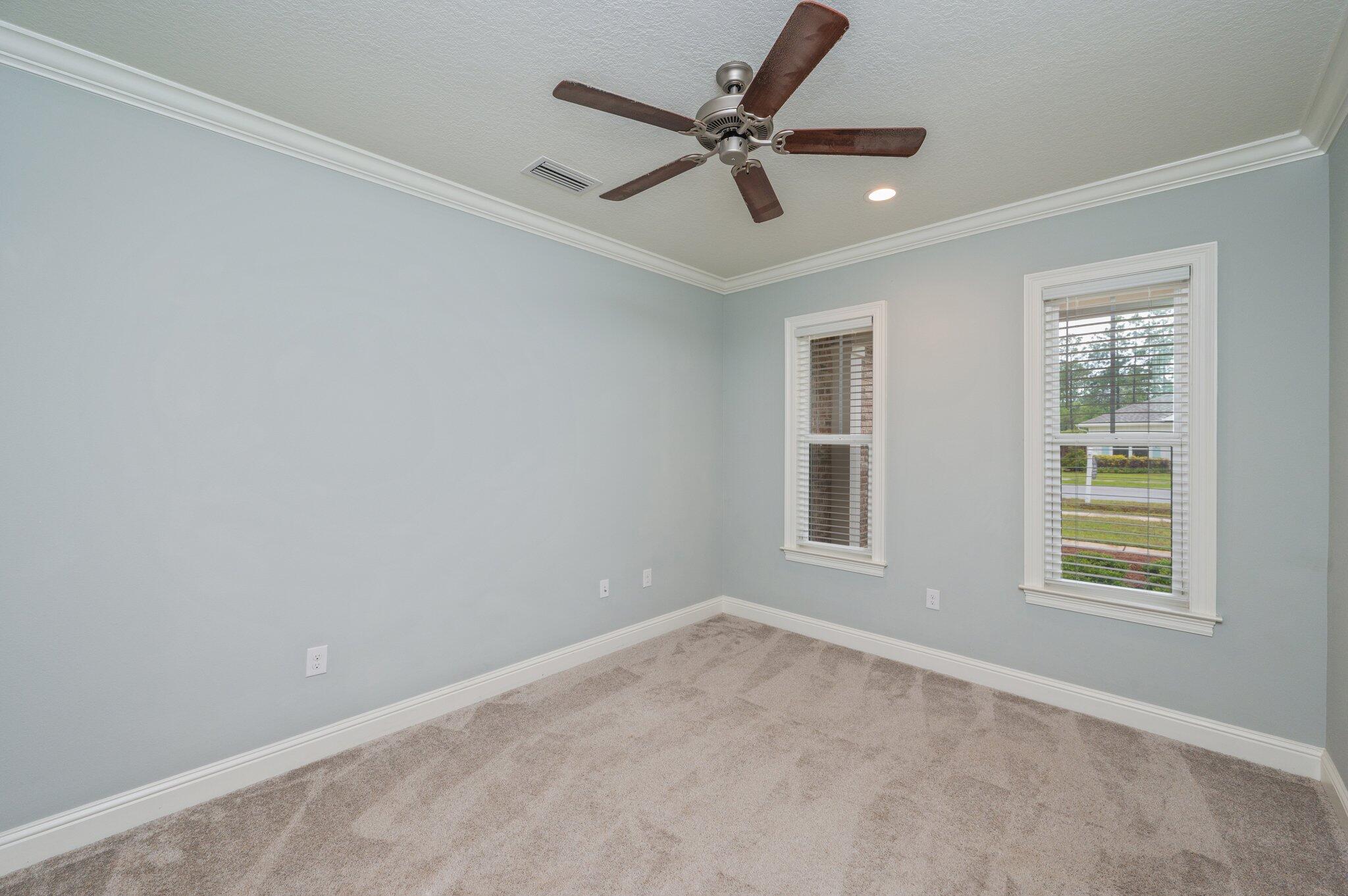 125 Perimeter Place Freeport, FL 32439 - Photo 4 of 26 an empty room with ceiling fan and windows