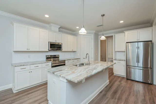 a kitchen with a refrigerator a sink and cabinets