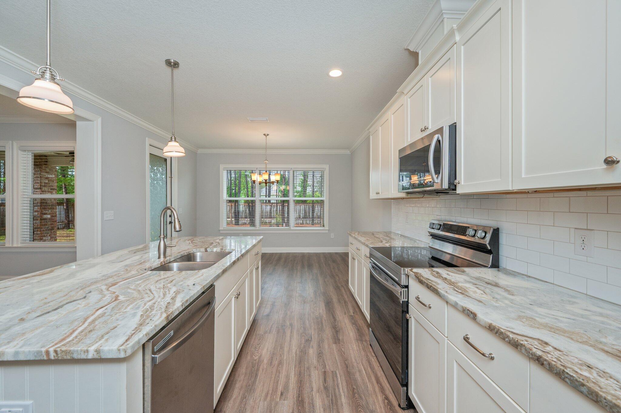 125 Perimeter Place Freeport, FL 32439 - Photo 7 of 26 a kitchen with granite countertop a sink and stove top oven