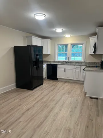 a view of kitchen with stainless steel appliances granite countertop a stove and a sink