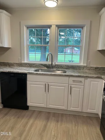 a kitchen with granite countertop white cabinets and white appliances