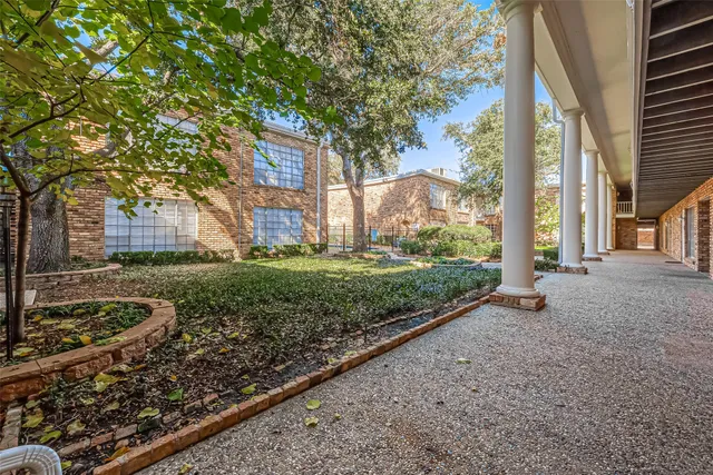 a view of a garden with large trees