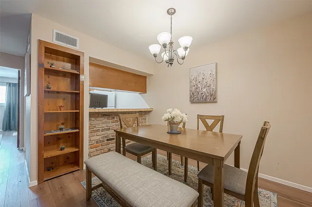 a view of a dining room with furniture a chandelier and wooden floor
