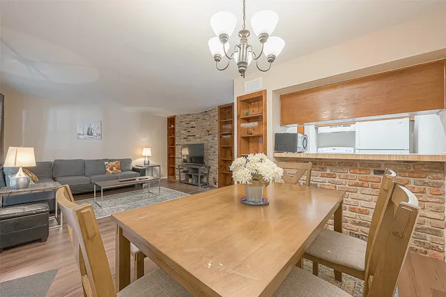 a view of a dining room with furniture a chandelier and wooden floor