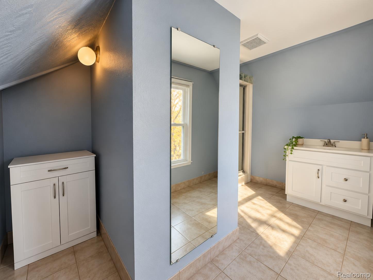 21761 Middlebelt Road Farmington, MI 48336 - Photo 14 of 21 White vanity with integrated sink, tiled flooring, built-in storage cabinet, and wall-mounted light fixture