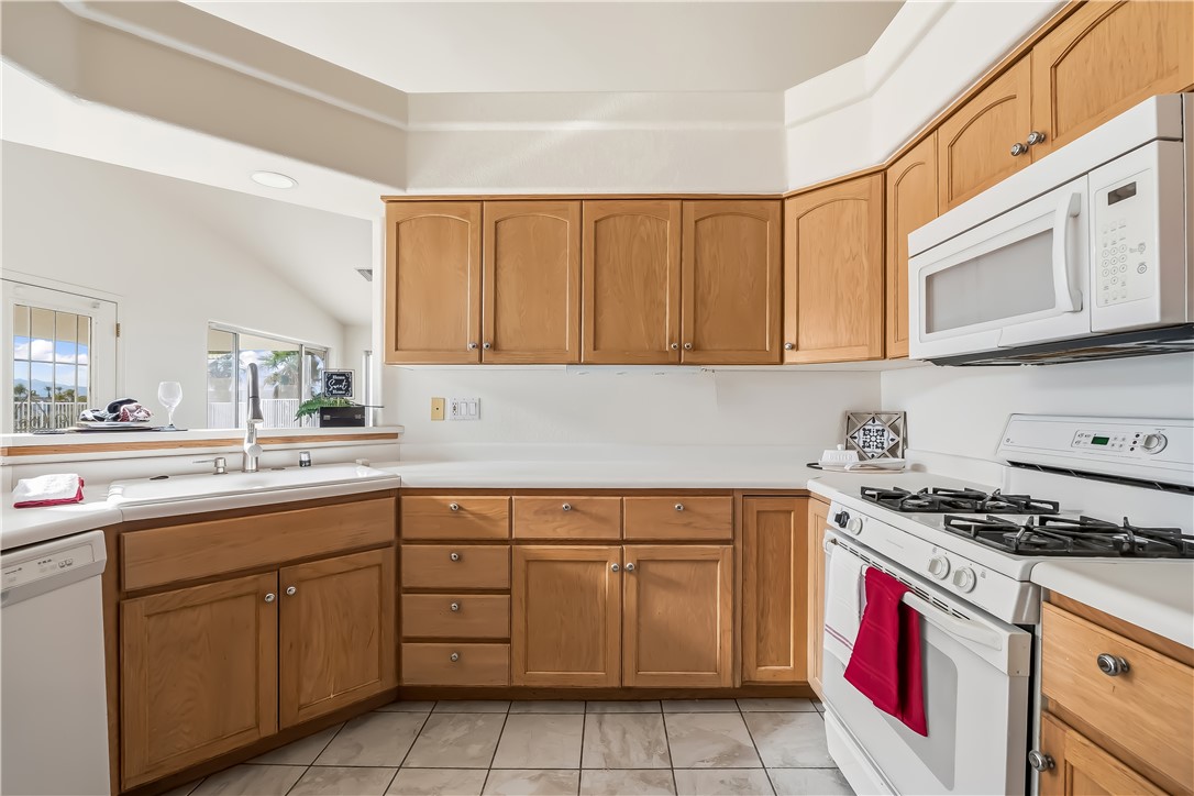 2853 Winchester Road Bullhead City, AZ 86442 - Photo 20 of 40 Kitchen featuring wood cabinetry, white countertops, a built-in microwave, a gas range, and a dishwasher