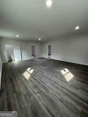 a view of empty room with wooden floor and windows