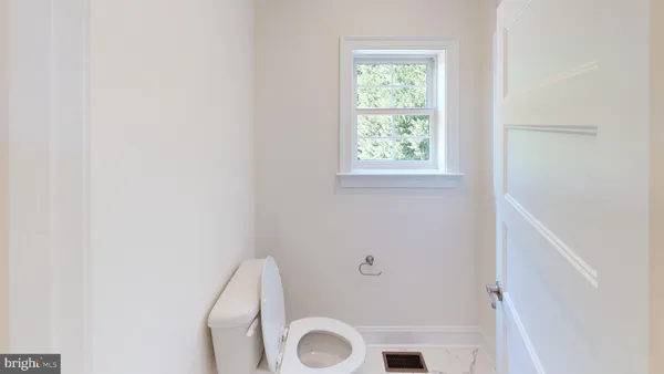 a bathroom with a toilet and a window