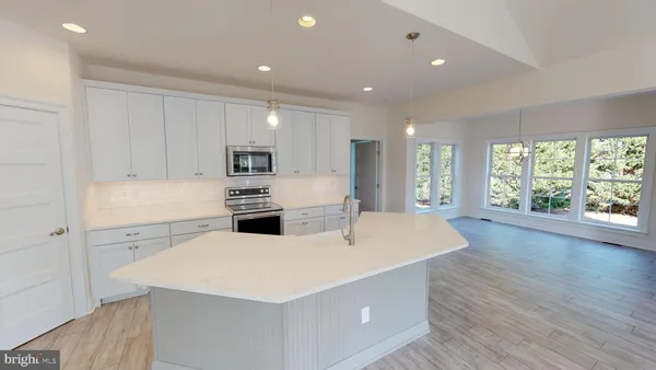 a kitchen with a sink a wooden floor and white cabinets