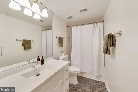 a bathroom with a sink a toilet and shower curtain